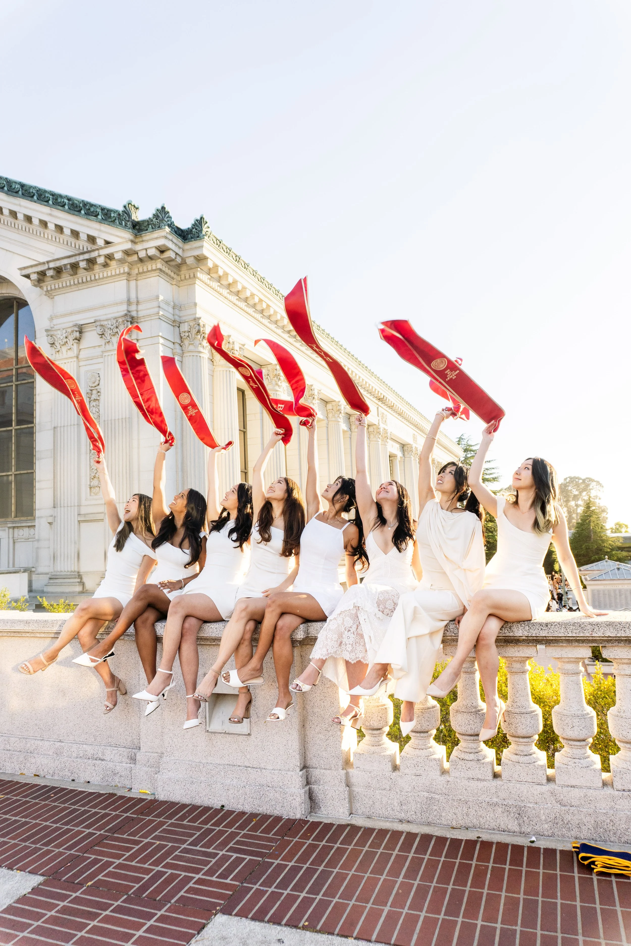 Brothers throwing BAΨ sashes at Doe Library